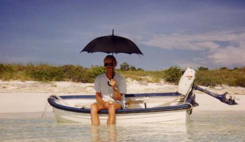 Webmaster keeping cool in the Bahamas Dinghy and umbrella